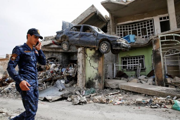 A member of the Iraqi Federal Police walks next to a destroyed house after their clashes with the Islamic State fighters in western Mosul