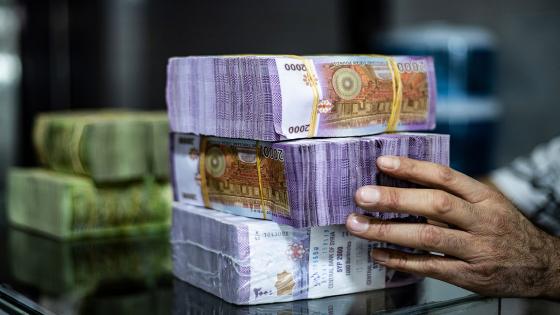 A merchant arranges stacks of Syrian pounds at a market in the Kurdish-majority city of Qamishli in northeast Syria on September 10, 2019. - The declining value of the pound is a sure sign of Syria's ailing economy. The civil war has battered the country's finances and depleted its foreign reserves. A flurry of international sanctions on President Bashar al-Assad's regime and associated businessmen since the start of the war in 2011 has compounded the situation. (Photo by Delil SOULEIMAN / AFP) (Photo credit should read DELIL SOULEIMAN/AFP via Getty Images)